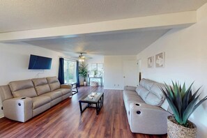 A spacious living room with two sofas, a coffee table, and a large plant. - 4BR Spacious Lakefront Retreat with Game Room (Hot Springs)