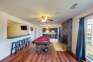 A pool table with stools, a bar area, and a stone fireplace. - 4BR Spacious Lakefront Retreat with Game Room (Hot Springs)