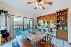 A dining area with a wooden table, chairs, and a ceiling fan. - 4BR Golf Course View Dog Friendly (Holiday Island)