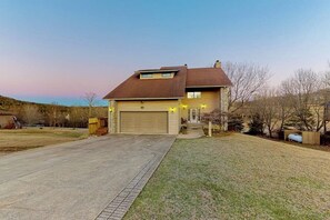 A two-story house with a garage, a front yard, and a driveway. - 4BR Golf Course View Dog Friendly (Holiday Island)