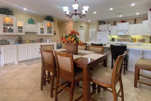 A spacious kitchen with white cabinets, a dining table with chairs, and a chandelier. - 2BR Serene lakefront condo with stunning views (Hot Springs)