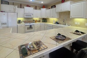 A kitchen with white cabinets, a large island, and a microwave. - 2BR Serene lakefront condo with stunning views (Hot Springs)