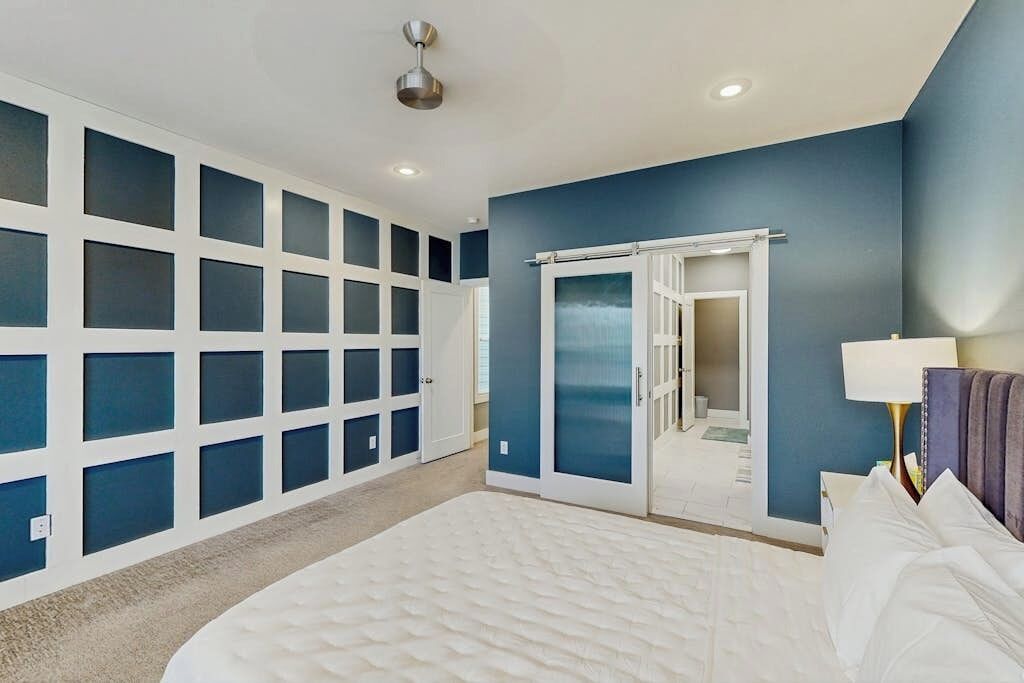 Un dormitorio con una cama grande, un vestidor y vistas a través de una puerta.