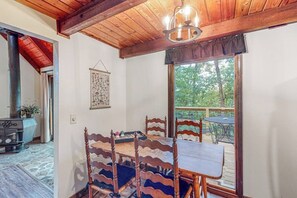 Ein Essbereich mit Holzboden, einem Tisch mit Stühlen und Blick ins Freie.