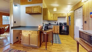 A kitchen with wooden cabinets, a central island, and a built-in oven. - Quiet 2BR Lakeview Dog Friendly - Deck - Firepit (Eureka Springs)
