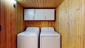 A laundry room with two white washing machines and a white cabinet above them. - Quiet 2BR Lakeview Dog Friendly - Deck - Firepit (Eureka Springs)