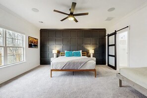 A bedroom with a bed, a ceiling fan, a window, and a door. - Lake Brittany Lodge | Lake View, Deck & Firepit (Bella Vista)