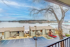 A view of a waterfront property with a parking lot, a red car, and a tree. - 2BR Cozy Condo, Enjoy the View, Community Pool (Hot Springs)