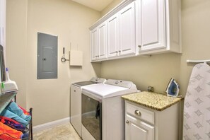 A laundry room with a washing machine, dryer, and ironing station. - 5BR Lakefront home - Dock, 2 kitchens, pool table (Hot Springs)