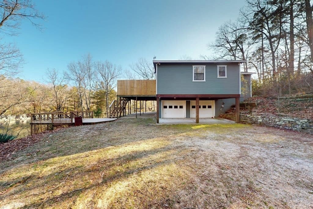 A two-story house with a garage, a deck, and a staircase leading to an upper level.
