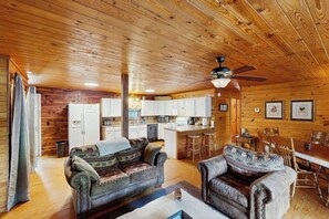 L’intérieur d’une cabane est doté d’un plafond en bois, d’un ventilateur de plafond, d’un coin cuisine et d’un espace repas.
