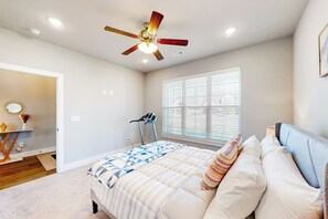 A bedroom with a bed, a ceiling fan, a treadmill, and a window with blinds. - 4BR home with foosball & children's items, dogs ok (Bentonville)