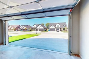 A garage with a clear view of a suburban neighborhood, including houses and a street. - 4BR home with foosball & children's items, dogs ok (Bentonville)