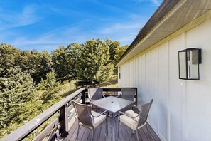 Eine Terrasse mit Tisch und Stühlen mit Blick auf eine bewaldete Landschaft.
