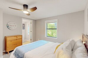 A bedroom with a bed, a dresser, a ceiling fan, a window, and a door. - 3BR dog-friendly with decks, foosball, & views (Bella Vista)