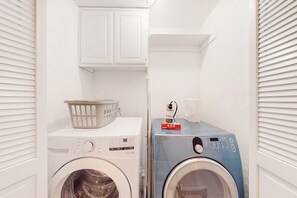 A laundry room with two washing machines, one white and one blue, and a basket on the white machine. - 3BR dog-friendly with decks, foosball, & views (Bella Vista)
