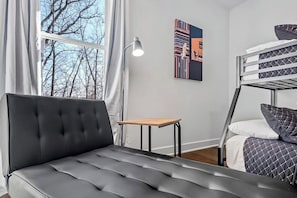 A modern room with a sofa, a bunk bed, a small table, and a lamp. - The Dutchman | 4BR, Deck, Firepit & Fireplace (Bella Vista)