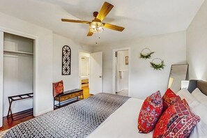 A bedroom with a bed, a ceiling fan, a wardrobe, and a desk. - Large 3BR - Balcony - Firepit - Garage Parking (Bentonville)