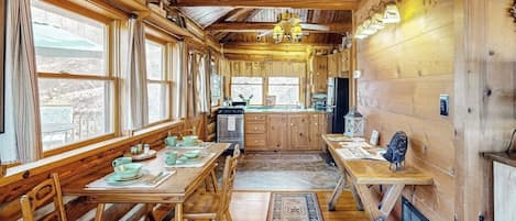 Ein Holzblock mit Essbereich, Küche und großen Fenstern.