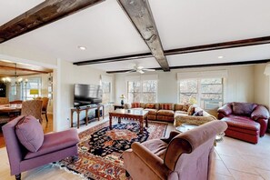 A spacious living room with a large rug, leather sofas, and a television. - Spacious 5BR - Fireplace - Deck - Firepit (Eureka Springs)