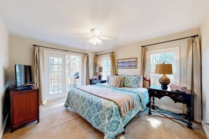 A bedroom with a bed, bedside tables, a ceiling fan, and a television. - Spacious 5BR - Fireplace - Deck - Firepit (Eureka Springs)