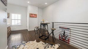 A hallway with a dining area, a sign indicating no reservations, and a poster on the wall. - Stylish 2BR -  W&D - Downtown Location (Bentonville)