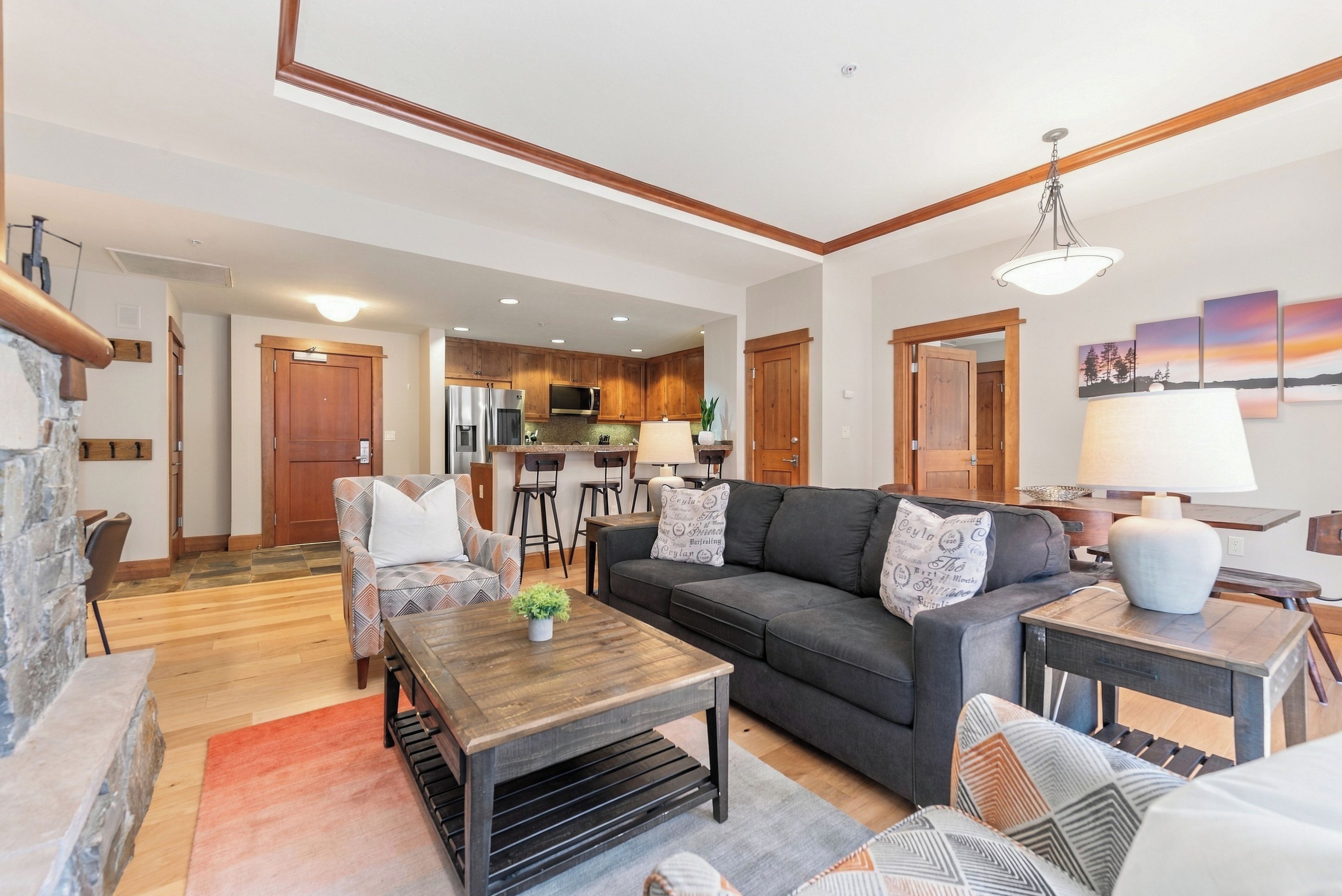 A modern living room with a sofa, coffee table, and a dining area with chairs.