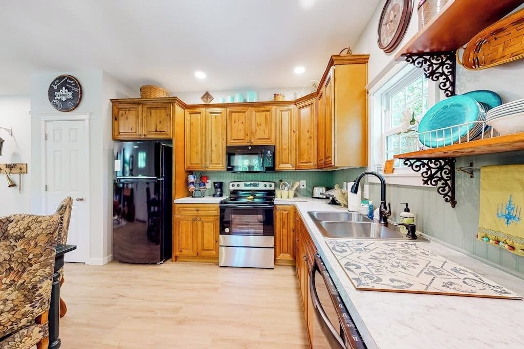 A kitchen with wooden cabinets, stainless steel appliances, and a patterned backsplash.