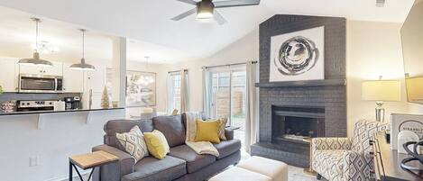 Una sala de estar moderna con chimenea, un sofá y una mesa de centro.