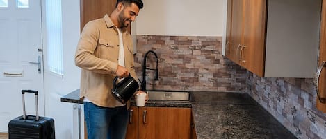 A modern kitchen with a gas stove, wooden cabinets, and a tiled backsplash.