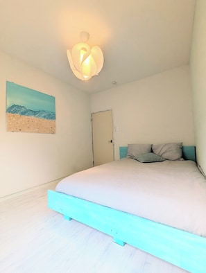 A bedroom with a bed, a door, a wall-mounted light fixture, and a painting of a beach scene. - Minamiizu Shimoda/OpalNest/ArtHouse/10p/PetsOK/New (賀茂郡南伊豆町)