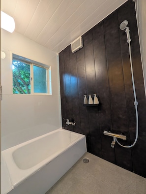 A modern bathroom with a bathtub, a shower, and a window. - Minamiizu Shimoda/OpalNest/ArtHouse/10p/PetsOK/New (賀茂郡南伊豆町)