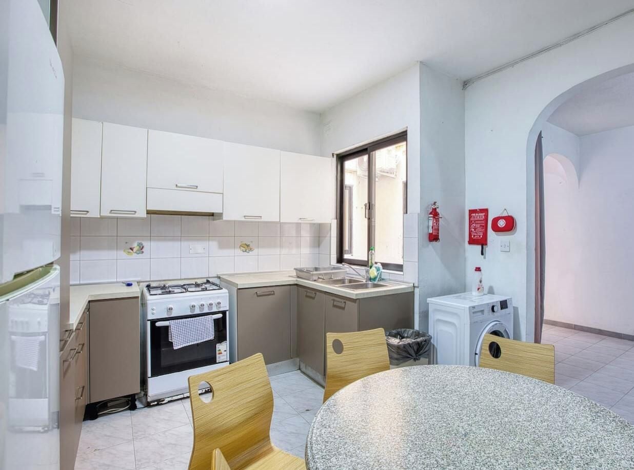 Una cucina funzionale con piano cottura, lavello e lavatrice.