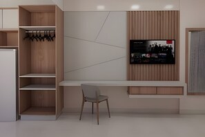 A modern interior with a built-in TV, wooden shelving, and a seating area. - HOTEL SPAZZIO DiRoma  (Caldas Novas)