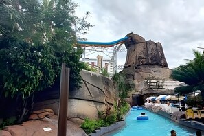 Un parc aquatique doté d’une grande formation rocheuse, d’un toboggan aquatique et d’un espace piscine.