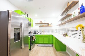 A kitchen with green cabinets, a stainless steel refrigerator, and a coffee machine. - Spacious 4-Bedroom Miami Home for Group Stays & Gatherings (Miami)