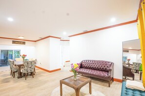 A living room with a sofa, a coffee table, and a dining area with chairs and a table. - Spacious 4-Bedroom Miami Home for Group Stays & Gatherings (Miami)