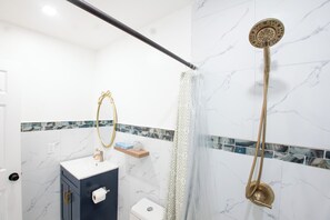 Un bany amb dutxa, vàter i rentamànega.