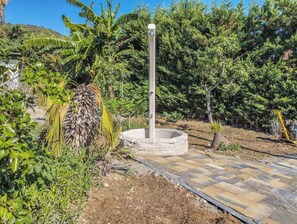 A garden with a central water feature, surrounded by various plants and trees. - Casa Sale (Arma di Taggia)