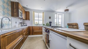 A modern kitchen with wooden cabinets, a stainless steel sink, and a built-in oven. - Lovely 2 Bedroom Coastal Flat - Pass the Keys (Bognor Regis)