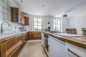 Een moderne keuken met houten kastjes, een roestvrijstalen spoelbak en een ingebouwde oven.