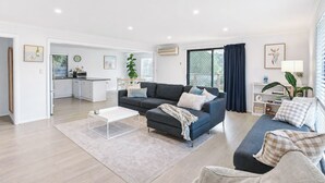 A modern living room with a grey sofa, a coffee table, and a dining area in the background. - Stones Throw - Located right in the heart of Robe (Robe)