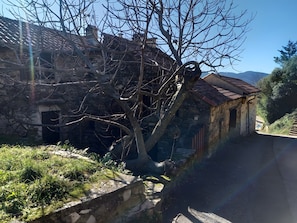 A stone building with a sloped roof, a tree in front, and a clear sky. - Holiday Home 'Gîte La Belle Étoile' with Mountain View and Private Terrace (Saint-Julien)