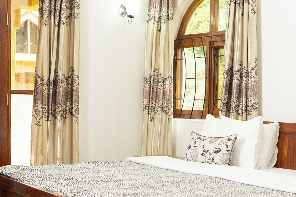 Un dormitorio con cama de madera, colcha estampada y cortinas con diseños florales.