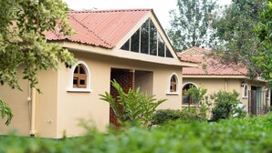 A two-story building with a red-tiled roof, arched windows, and a brick entrance.