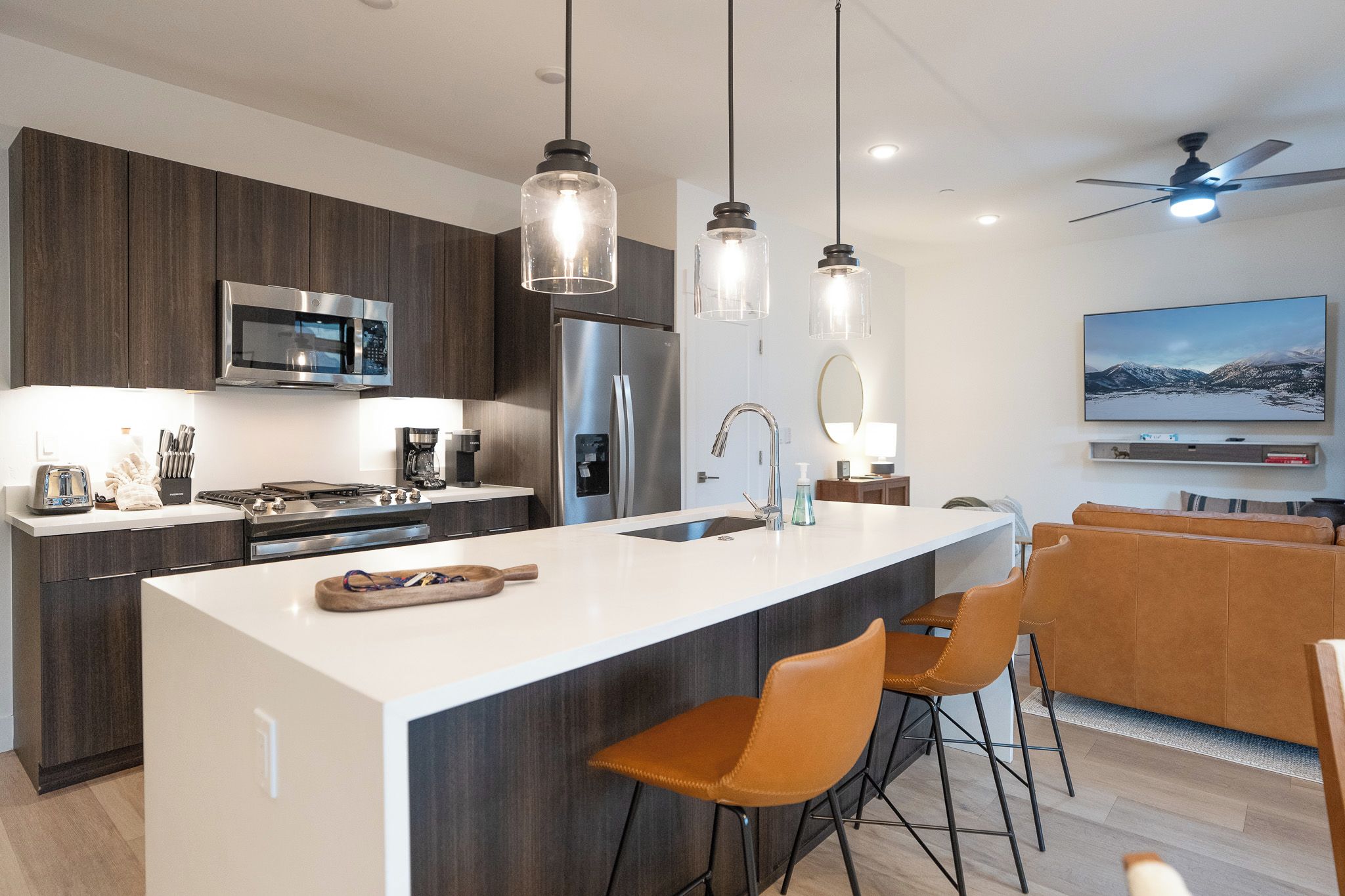 A modern kitchen with a central island, stainless steel appliances, and pendant lighting.