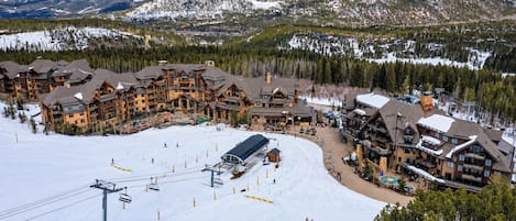 A ski resort with multiple lodges, a ski lift, and a snow-covered landscape.
