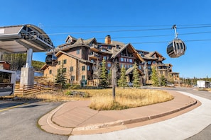 A multi-story hotel with a ski lift, surrounded by trees and a clear sky. - Crystal Peak Highpoint Condo: Ski In/Out, Mountain Views (Breckenridge)