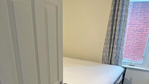 A small bedroom with a single bed, a door, a window with curtains, and a carpeted floor. - Comfortable & Cozy Private Room in a Shared House (Room1) (Toronto)