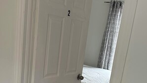 A room with a white door marked with the number 2, a bed with a white mattress, and a grey carpet. - Comfortable & Cozy Private Room in a Shared House (Room1) (Toronto)